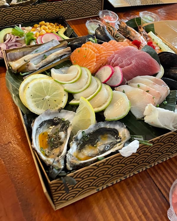 Plateau op bananenblad met oesters, sashimi van zalm en tonijn, zeebaars, scheermessen, mosselen en king crab