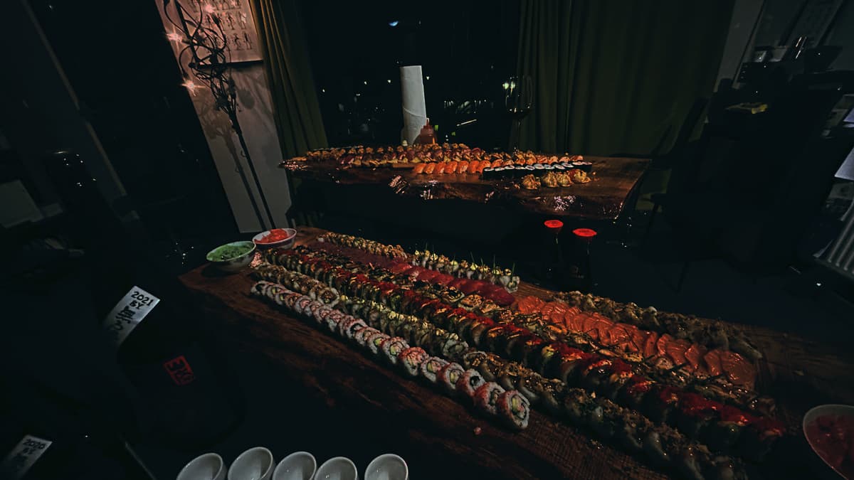 Een opgebouwd sushibuffet over de volle lengte van een houten plank